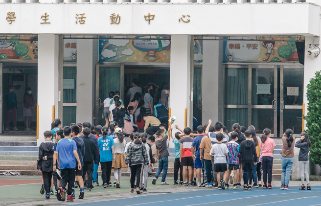 新冠肺炎本土疫情持续延烧，校园频频爆发确诊个案，北市大安区某国小30日传出一名资优班老师发现有症状后主动快筛确诊，卫生局也紧急派员到校进行900人採检，目前先以资优班停课为主，若还有新增个案将全校停课；师生带队前往学校活动中心快筛。(郭吉铨摄)