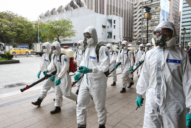 口罩令4月鬆綁無望。圖為化學兵在路上消毒的畫面。（本報系資料照）