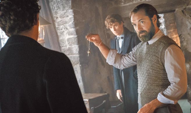 裘德洛（右）飾演年輕時期的鄧不利多，與艾迪瑞德曼一起對抗葛林戴華德。（華納兄弟提供）