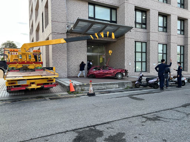 台東民眾因不滿保險公司理賠刻意刁難，31日特地以拖吊車將廢棄車輛擋在保險公司門口。（蔡旻妤攝）