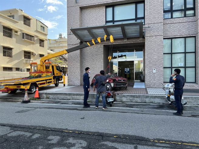 台東民眾因不滿保險公司理賠刻意刁難，31日特地以拖吊車將廢棄車輛擋在保險公司門口。（蔡旻妤攝）