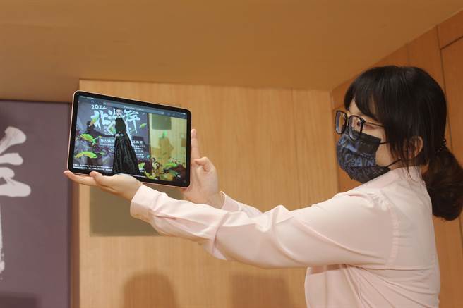 「北海岸时尚艺术季」设置扩增实境AR走秀，民眾扫描QR-Code后，即能透过手机看到穿着「针织女王」潘怡良设计服饰的特儿漫步于渔港实境中。（陈慰慈摄）