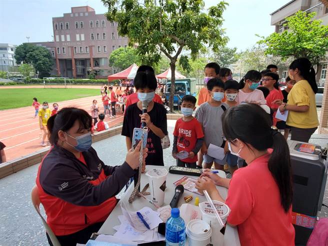 镇南国小今年以童玩、游戏、民俗为儿童节主题让孩子体验夜市的乐趣，这一关是卡拉ＯＫ。（周丽兰摄）