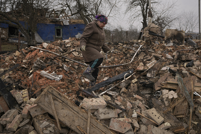 在俄军攻击下，乌克兰首都基辅郊区的民宅被夷为平地，一名妇人30日在化为一片瓦砾的家中，设法寻找个人物品。（美联社）
