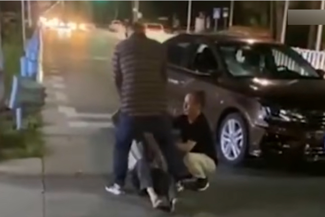 男子酒驾肇事后不但对着男性伤者叫嚣，还转头作势往另一名女性伤者嘴里撒尿。（图／翻摄自微博）