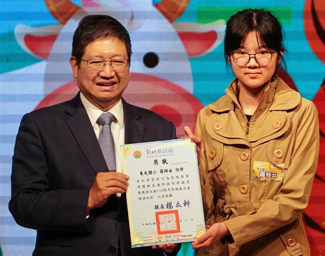 县长杨文科（左）颁奖给模范儿童关西镇东光国小罗梓云（右），在校学习与行为表现优异。（罗浚滨摄）