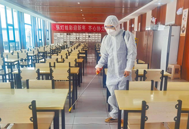 上海以黄浦江为界，採取浦东、浦西「鸳鸯锅式」分区方式先后实施封控。图为防疫人员在上海浦东新区的工地食堂内消毒。（新华社）