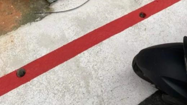 一名男網友聲稱，昨日上午將機車停在白線上，但下午要牽車離開卻發現被開罰單，地面也被畫上紅線，他氣得大罵「土匪政府」。（圖／翻攝自爆料公社App）