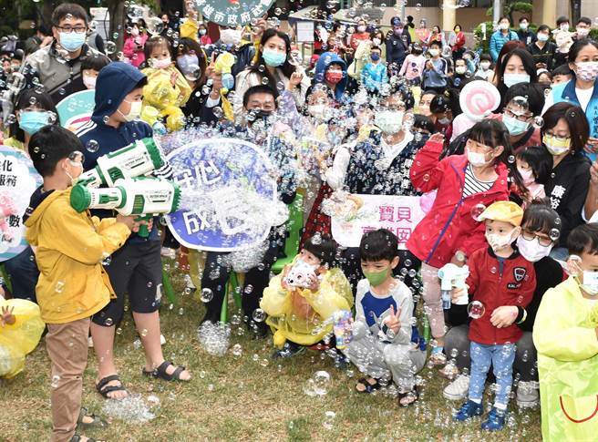 高雄市長陳其邁2日出席社會局兒童節泡泡派對活動，被小朋友以泡泡槍圍攻。（林瑞益攝）