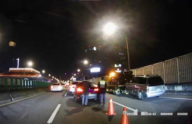 保大員警開啟巡邏車警示燈閃爍、設置三角錐，防範二次追撞事故發生，以保護車禍現場人車安全。(翻攝照片／林郁平台北傳真）
