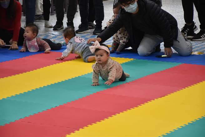 兒童嘉年華嬰兒爬行比賽，小寶貝意志堅定地朝前進。（謝明俊攝）