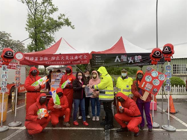桃园市消防局第二大队富冈分队2日至5日于辖内杨梅第一公墓办理防火宣导活动以及人车驻点警戒，结合影集鱿鱼游戏内容。（消防提供）