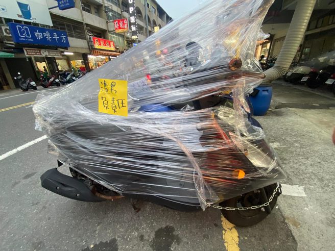 1名网友在路边发现1辆机车被塑胶膜狠狠封住，上头还贴纸条写「渣男负责任」，引发热议。（翻摄自脸书「爆废公社」）