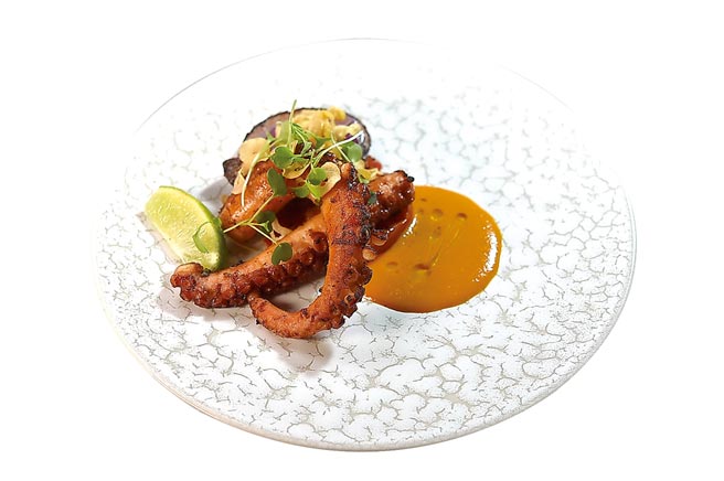 〈炙烤章鱼〉的章鱼脚外酥内嫩且入味，主厨用特制冬荫功酱提味，呈现南洋风味。图／姚舜