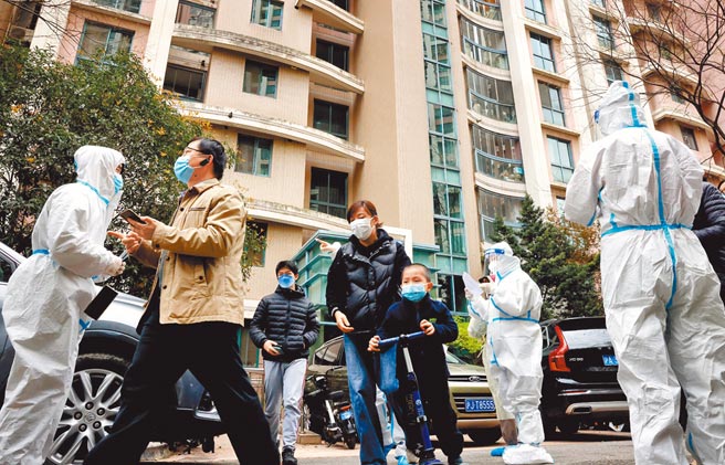 上海市普陀區長風新村錦綠居民區的住戶在疫情防控義工的引導下，於1日走出家門進行核酸檢測。（新華社）