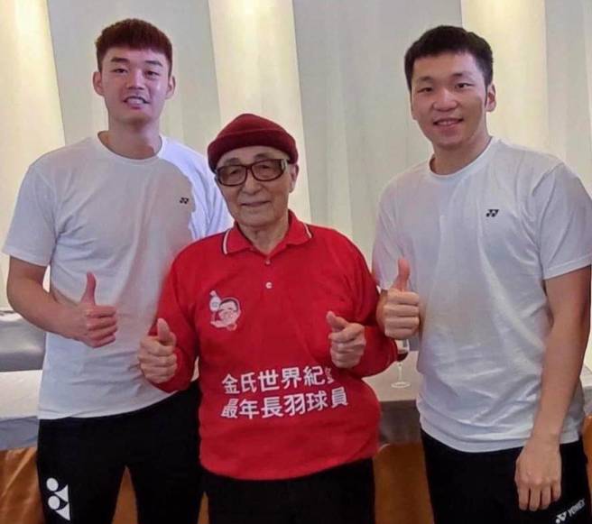 東京奧運羽球男雙金牌李洋（右）、王齊麟（左）與百歲人瑞林友茂（中）。（中華全民羽球發展協會提供）