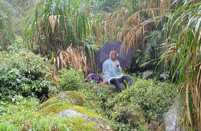 彰化72岁阮姓老翁受困溪头山区2天，被搜救人员发现时满头血迹、冷静撑伞坐在大石头上。（记者爆料网）