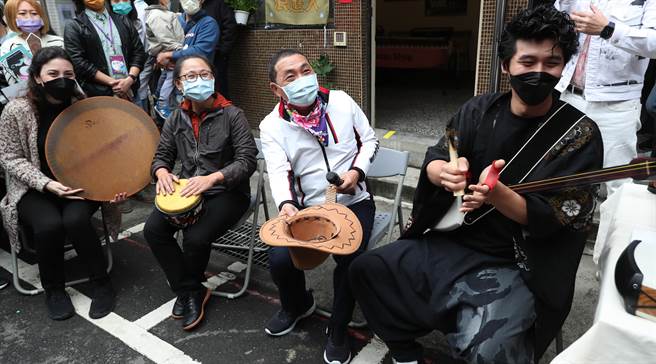 新北市長侯友宜（中）3日出席新北市多元文化節，與日本沖繩三線琴（右）、非洲鼓及伊朗的DAF鼓一同即興演出，體驗異國文化風情。表演後隨即拿下戴著的牛仔帽向現場的民眾討賞。（鄭任南攝）