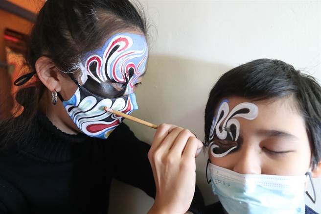 新北市多元文化節3日在新北市空軍三重一村熱鬧登場，活動以「當我們混在一起MIX Together」為主題，展示混入新北市的各種文化，一位民眾在混宮廟館中接受傳統廟會活動時將八家將臉譜畫在臉上。（鄭任南攝）