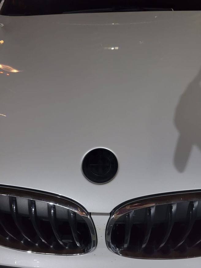  一名男子心疼爱车前挡玻璃被神秘物敲中，当他下车查看后，竟发现是爱车车标脱落造成的。（翻摄自脸书爆废公社）