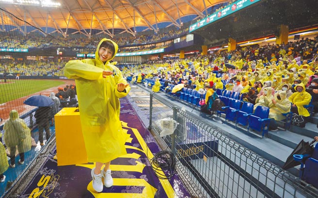 中职33年开幕战2日在台中洲际棒球场开打，地主中信兄弟的「啦啦队女神」峮峮不畏雨势，穿着雨衣热舞带动现场气氛。（中央社）