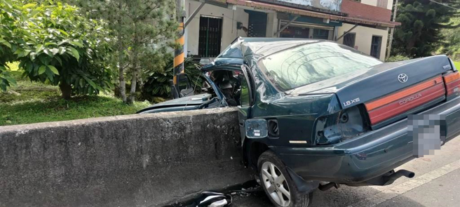 24歲林姓男子今上午駕車行經花蓮縣富里鄉台9線289.5K處，疑因車速過快，過彎不慎，自撞路旁水泥護欄，左側車身直接呈現「凹」字型包覆著護欄，所幸林命大，意識清楚，僅左腿粉碎性骨折，已送往醫院治療。（花蓮縣消防局第三大隊提供／羅亦晽花蓮傳真）