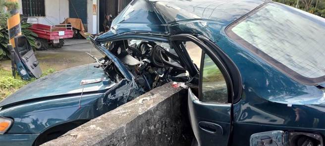 24歲林姓男子今上午駕車行經花蓮縣富里鄉台9線289.5K處，疑因車速過快，過彎不慎，自撞路旁水泥護欄，左側車身直接呈現「凹」字型包覆著護欄，所幸林命大，意識清楚，僅左腿粉碎性骨折，已送往醫院治療。（花蓮縣消防局第三大隊提供／羅亦晽花蓮傳真）

