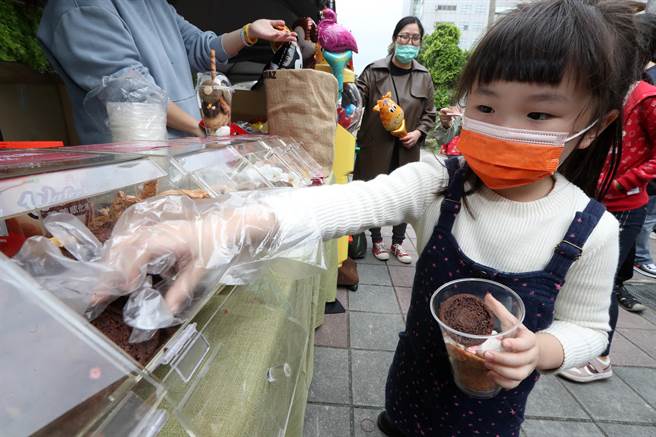 參加「2022台北甜點節」的店家柳橙王子推出餅乾放題活動，讓民眾自己拿著空杯裝餅乾。（劉宗龍攝）