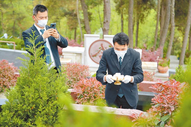 4月3日，工作人员在进行代祭服务并进行视频录制。（中新社）