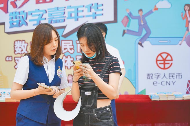 中国人民银行宣布增加11座城市作为数位人民币试点地区。图为北京一家交通银行分行的工作人员正引导民眾开通数位人民币钱包。（新华社）
