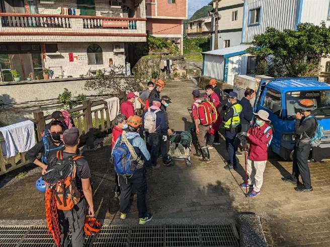 消防人员将疑似热痉挛男子搬运下山。（翻摄画面）