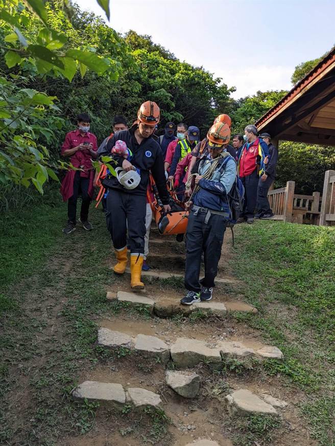 消防人员将疑似热痉挛男子搬运下山。（翻摄画面）