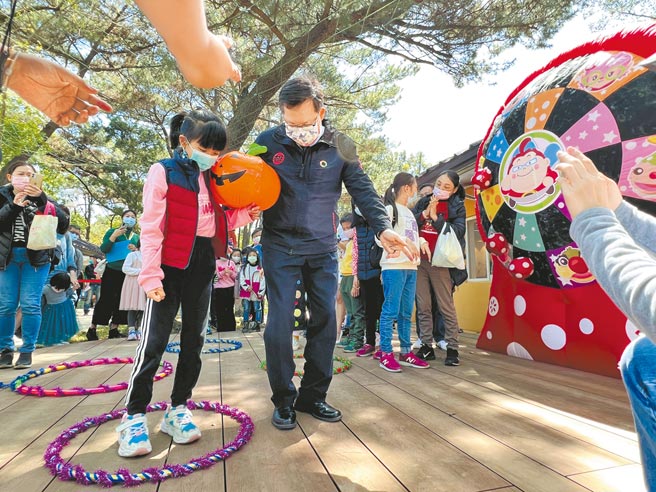 桃园儿童玩具图书馆欢庆1周年，甫拿下经营权的如果儿童剧团，4日搭配儿童节推出各项活动，吸引逾千名亲子同乐，市长郑文灿也和小朋友一起玩夹球障碍闯关游戏。（蔡依珍摄）