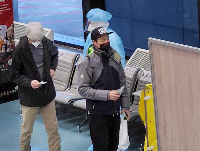 台湾羽球国手周天成（右）6日清晨搭机抵台，落地筛检确认阳性反应，并随即在检疫人员陪同下，从空侧机坪搭乘救护车送医。（读者提供）