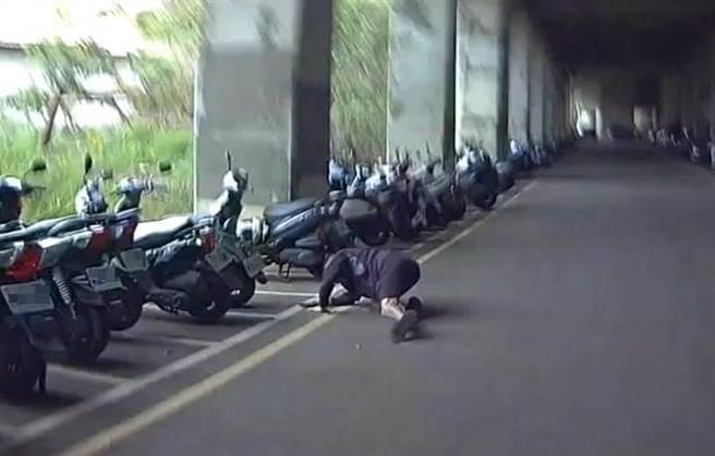 1名通緝犯被友人騎機車搭載，行經後龍鎮中華路時遇到巡邏警車慌忙跳車逃跑，數度摔倒。（竹南警分局提供／謝明俊苗栗傳真）