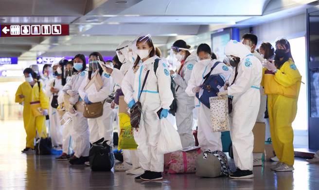在桃園機場入境管制區內，一群落地採檢為陰性反應的菲籍移工準備通關入境。圖中非新聞當事人。（范揚光攝）
