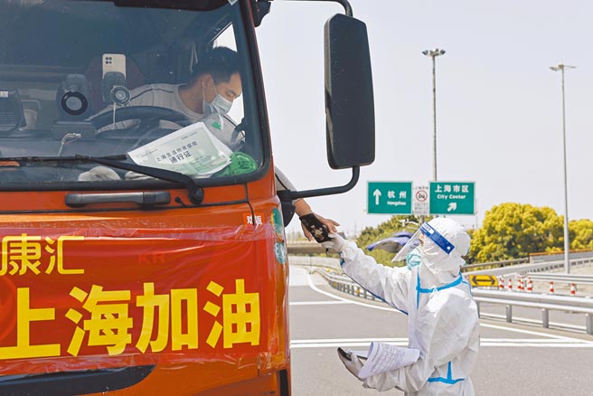 上海防疫官員表示，目前疫情仍嚴峻。自4月2日零時起，被允許離開上海的人員除須持有48小時內核酸檢測陰性證明外，還須提供24小時內抗原檢測陰性證明。一輛貨車上掛有「上海加油」布條。（中新社）
