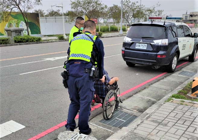 台中市警察局第5分局四平派出所员警推着老翁轮椅的亲民背影，令路过人车感动按讚。（民眾提供／卢金足台中传真）