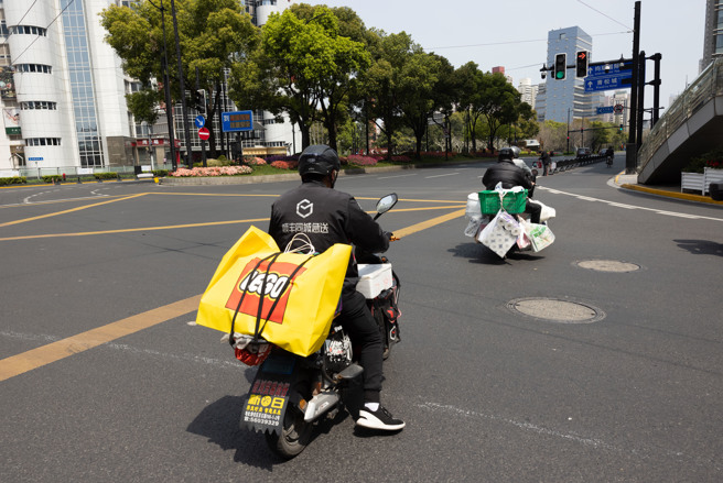 上海官方今天宣布放寬部分限制，准許快遞員等保供人員在嚴格篩檢前提下，出門上班。（圖／新華社）