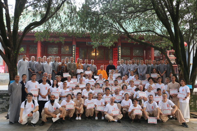 2018 年来自美国、瑞典、德国、印度尼西亚等20多个国家的60余名海外少林弟子，归山朝拜河南嵩山少林寺，在获颁少林武学认证后与释永信合影。（图／中新社）
