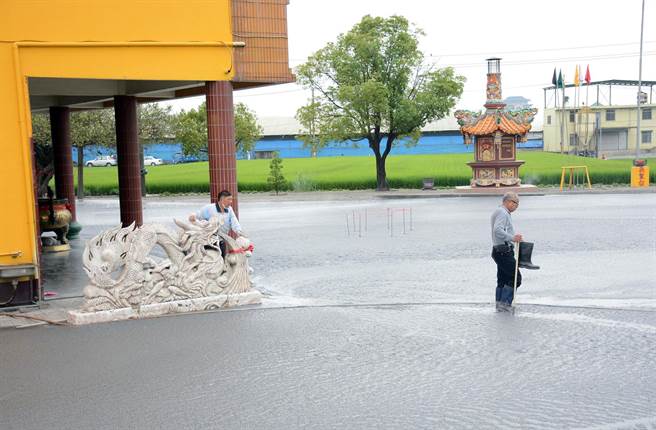 万丹泥火山喷发，皇源圣殿被滚滚泥流包围，民眾出入显得小心翼翼。（林和生摄）