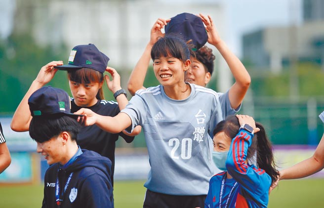 台体大卓莉萍（20号）在大专足球联赛女一级冠军战踢进致胜PK，颁奖时俏皮的将冠军纪念帽戴在台体助教赖丽琴头上。（李弘斌摄）