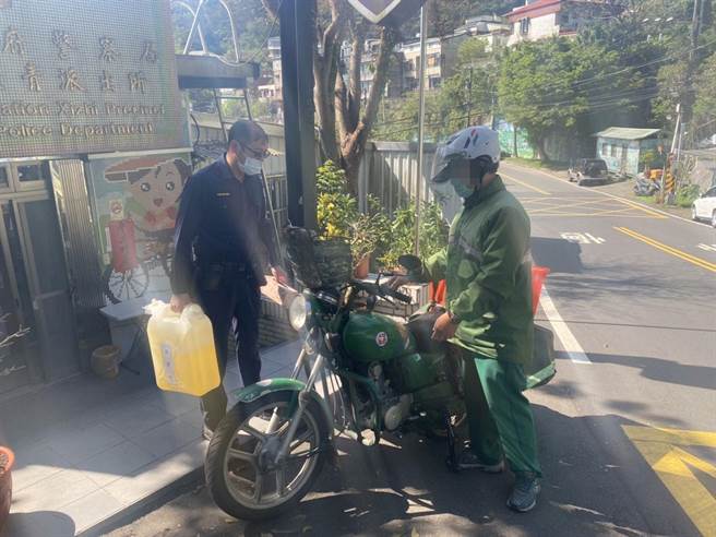 新北市汐止警分局长青派出所警员陈昌武协助邮差，利用预备汽油救援。（汐止警分局提供）