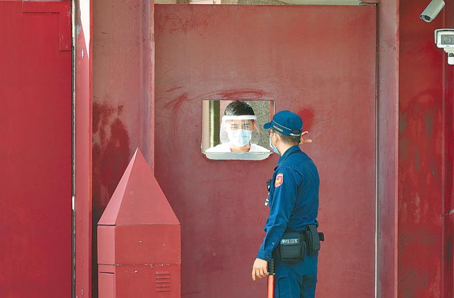 图为官邸内身穿加强防护装备的安全人员与门外的警卫，隔着大门的小窗口交谈。（郑任南摄）