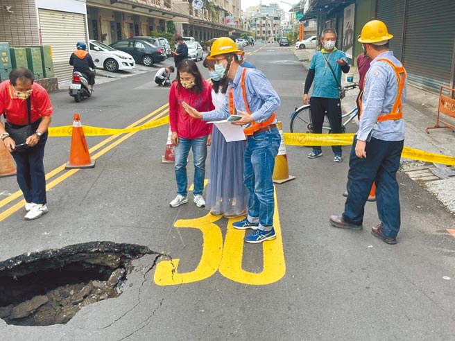 高雄市凤山区文化路、文昌街口路面9日上午突然出现直径两米的天坑，经查就是地底污水管线破损造成地基流失所致。（民眾提供／袁庭尧高雄传真）