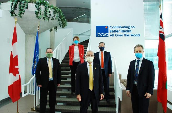 （加拿大经济发展、就业创造暨贸易部长Vic Fedeli (中)，在保瑞加拿大厂总经理Andrew Ehrat (右一) 与高阶主管偕同下参观厂区生产线。图／业者提供）