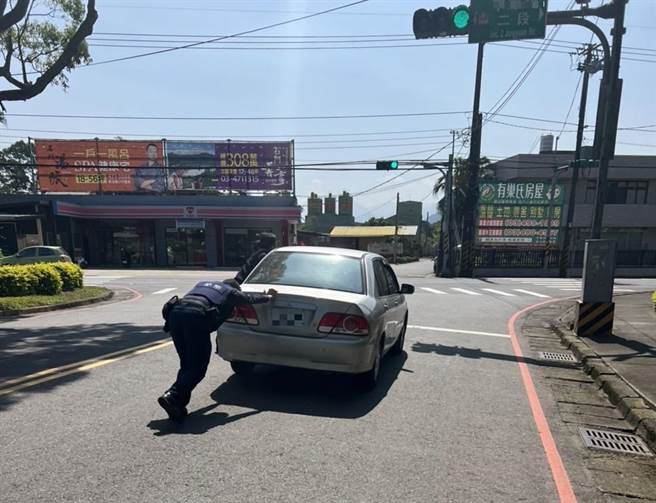 男子驾车抛锚路中，龙潭警烈日下挥汗推车救援。(警方提供／吕筱蝉桃园传真)