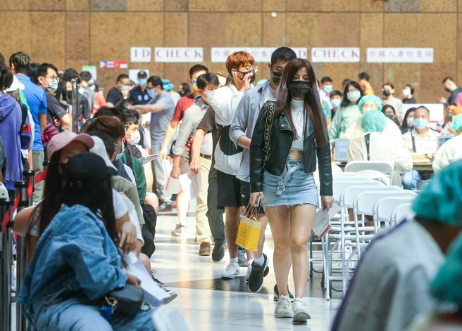 中央流行疫情指揮中心12日公布，國內新增663例新冠確定病例，其中551例為本土病例，境外移入新增112例，指揮中心再次呼籲，民眾應落實手部衛生、佩戴口罩等個人防護措施，並主動配合各項防疫措施。圖為北車疫苗接種站，再度湧入施打潮。（粘耿豪攝）