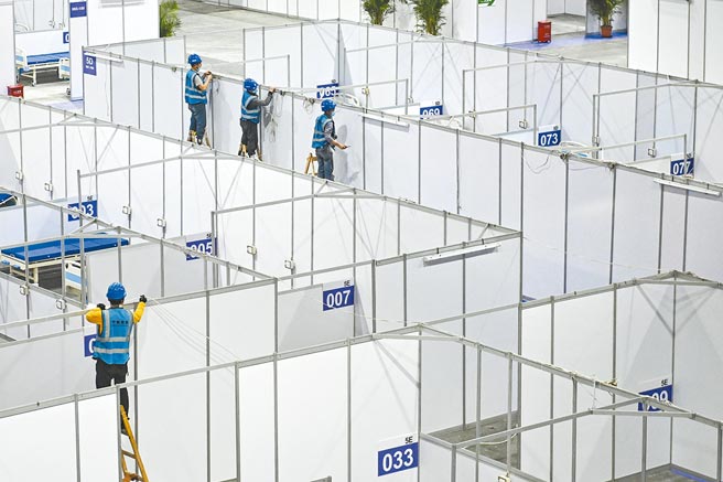 廣州疫情升溫，10日施工人員在琶洲會展中心建造方艙醫院。（中新社）