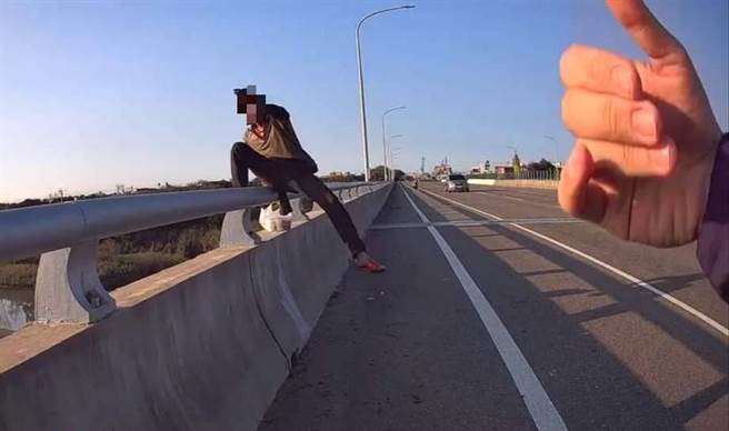 竹南警分局後龍分駐所員警保護泰國籍移工離開後龍大橋。（竹南警分局提供／謝明俊苗栗傳真）